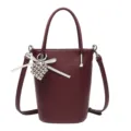 Dark red leather bucket bag with heart pendant, stylish mini crossbody handbag for women. - Burgundy