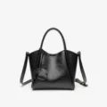 Black leather top handle crossbody bag with stylish pendant and comfortable strap. - Black
