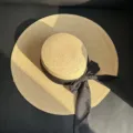Gros plan d'un chapeau de paille à large bord avec nœud ruban noir, idéal pour l'été à la plage. - M (56-58cm) / Noir