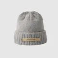 Close-up detail of the grey knitted beanie hat with a brown leather logo patch on the front cuff. - M (56-58cm) / Light Gray