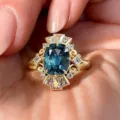Close-up of retro carved blue gemstone ring featuring intricate vintage filigree and sparkle detail. - Size 6 / Gold