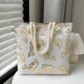 Sac cabas en toile blanche élégant avec motif dauphin doré et poignées en corde pour l'usage. - Dauphin doré