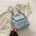 Variante de mini sac à dos floral bleu clair avec fermoir papillon pour le style quotidien. - Bleu