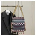 Détail d'un sac bandoulière tissé style ethnique, motifs géométriques et franges. - Violet