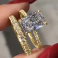 Primer plano detallado de un impresionante juego de anillos de dos piezas con piedra central brillante. - Talla 5 / Dorado