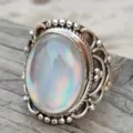 Vintage retro palace style silver ring with an iridescent oval stone and intricate carved details. - Size 6 / Antique Silver (A664)