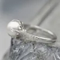 Exquisito detalle de un elegante anillo de perlas vintage con engaste de garra y circonitas. - Talla 6 / Oro blanco