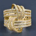 Primer plano detallado de un lujoso anillo dorado ancho y entrelazado con piedras de circón. - Talla 5 / Dorado