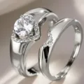 Vista detallada de anillos de pareja plateados con piedra central de corazón y banda curva elegante. - Talla 6 / Oro blanco