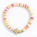 Gros plan sur le bracelet en perles d'argile polymère colorées avec pendentif croix tendance. - Kaki