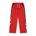 Red streetwear track pants side tribal embroidery detail casual athletic trousers close-up - S / Red