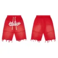 Detailed view of red streetwear shorts featuring rhinestone script text and distressed frayed hems. - S / Red