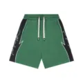 Green casual shorts with black side panels, elastic waist, and drawstring design details. - Green