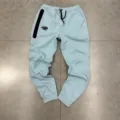 Detailed view of casual light blue fleece joggers with black drawstring and zip pocket. - M / Bottoms / Blue