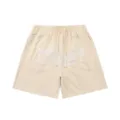 Beige waffle knit shorts with drawstring waist and embroidered front cursive text detail. - S / Bottoms / Apricot