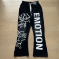 Detailed shot of black casual sweatpants featuring unique cherub graphics and bold letter print. - S / Bottoms / Black