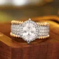 Exquisito anillo ancho bicolor con piedra central ovalada y bordes dorados texturizados. - Talla 6 / A315 Blanco