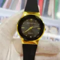 Vue détaillée d'une montre pour femme avec bracelet en silicone noir et lunette dorée. - Cadran Noir Bracelet Noir