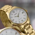 Goldfarbene Edelstahl Quarzur mit weißem Zifferblatt, römischen Ziffern und Kristallen. - Kein Kalender Weiß Zifferblatt Gold Band Damen