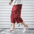 Men's red cargo capri pants with multiple pockets and drawstring hem for casual wear. - 29 / Burgundy