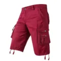 Detail view of men cargo shorts side pockets adjustable drawstring hem burgundy color fabric. - 30 / Burgundy