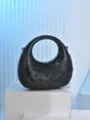 Detailed shot of a black rhinestone crescent evening bag with circle handle for party use. - Black