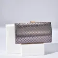 Detailed view of the elegant women's evening clutch bag with holographic polka dots and lock. - Black