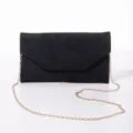 Detailed close-up view of the black glitter suede evening clutch bag with gold chain. - Black