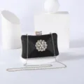 Elegant black glitter evening clutch with sparkling rhinestone flower brooch and gold chain. - Black
