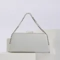 Close-up detail of silver evening clutch bag featuring sparkling rhinestone chain handle design. - Silver