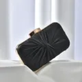 Black satin ruched evening clutch bag detail showing exquisite gold metal frame and elegant folds. - Black