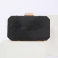 Close-up view of black glitter pleated evening clutch bag with gold metallic lock detail. - Black
