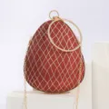 Detailansicht der roten Glitzer-Abendtasche mit edlem Goldgitter und stilvollem Ringgriff. - Weinrot