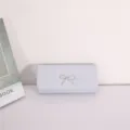 Silver glitter evening clutch bag with sparkling rhinestone bow detail closeup view. - Silver