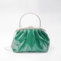 Green glossy pleated clutch bag close-up, metal frame kiss-lock evening bag details style. - Green
