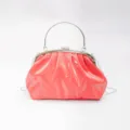 Detailed close-up view of the stylish coral pink pleated cloud bag with metallic handle. - Red