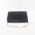 Close-up of black glitter pleated evening clutch bag with elegant golden chain strap details. - Black