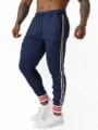 Vue détaillée de pantalon de jogging pour homme avec bandes contrastées et poignets côtelés. - S / Bleu marine