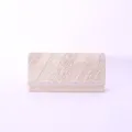 Detailed view of the elegant gold glitter evening clutch bag featuring a sleek metal accent strip. - Champagne