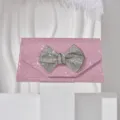 Rhinestone bow rhinestone detail on pink glitter evening clutch bag close-up view - Pink