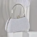 Elegant pearl evening bag detail, sparkling rhinestone clasp and metallic handle, fine texture. - Silver