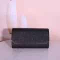 Detailed view of the black glitter evening clutch bag featuring a sleek gold metallic closure trim. - 22*6*12cm / Black