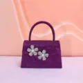 Detailed shot of the sparkling purple evening bag with stunning rhinestone flower decor close up. - Purple