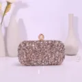 Detailed view of the sparkling sequin evening clutch bag with elegant pearl clasp and glittering rhinestones. - Gold