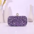 Detailed view of the sparkling purple rhinestone evening clutch bag with elegant pearl clasp. - Purple