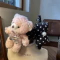 Nahaufnahme des flauschigen Bären-Haarclips mit glänzenden Strasssteinen und karierter Schleife. - Rosa