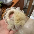 Detail shot of a sweet floral hair scrunchie with lace trim and crystal beads for women. - Yellow