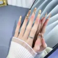 Modelo de mano con uñas postizas hechas a mano, degradado nude dorado, ojo de gato y pedrería. - XS / Stiletto Ojo de Gato con Kit de Herramientas