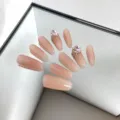 Primer plano de uñas postizas almendradas nude decoradas con elegantes diamantes rosas. - M / Estilo 082 Uñas Postizas
