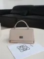 Elegant leather top-handle bag in soft beige color, featuring a chic twist-lock closure for daily wear. - Milk Tea